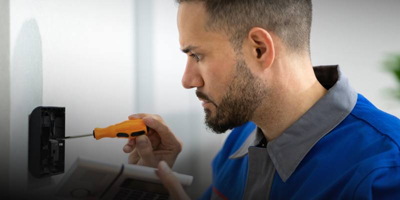Technician installing access control system with screwdriver, emphasizing professional security solutions for homes and businesses.